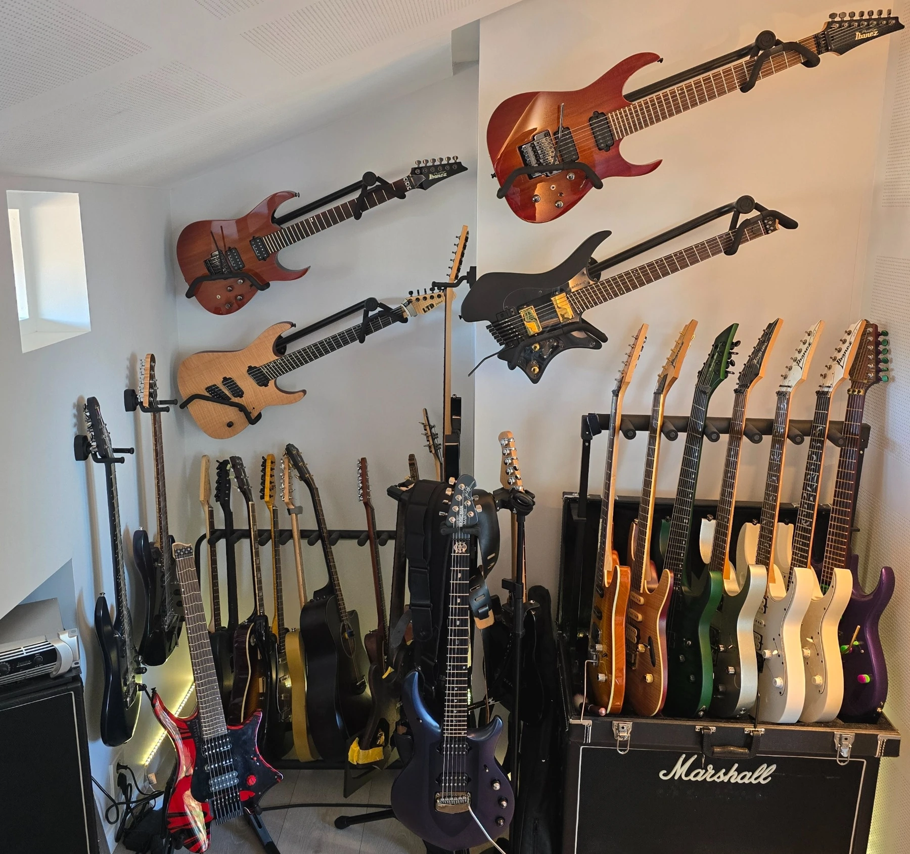 Tom’s guitar collection, displayed on wall mounts and floor stands
